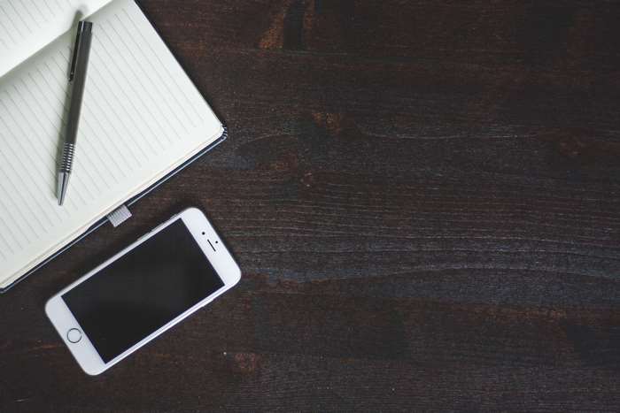 iPhone and notebook on a wooden table