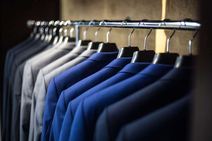 Row of suits on hangers in a wardrobe