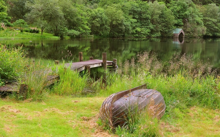 Upside down boat by a wooden dock on a lake