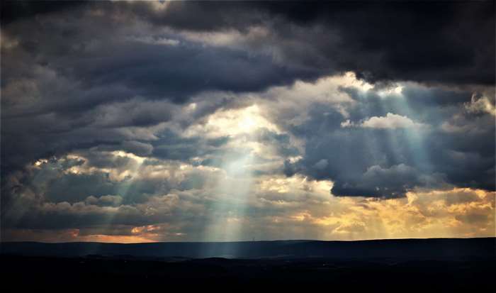 Sunbeams through storm clouds at sunset 4K