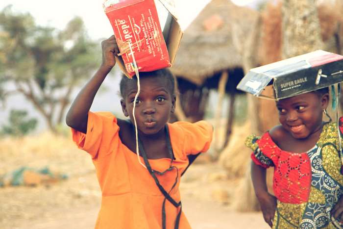 Children in Nigerian village with makeshift hats