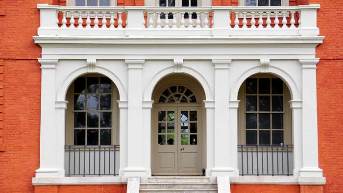 Red brick building with white arched entryway and double doors