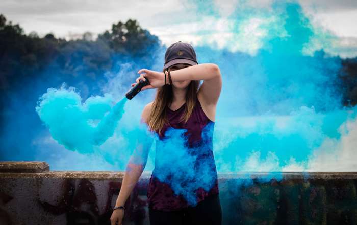 Woman holding blue smoke bomb outdoors 4K