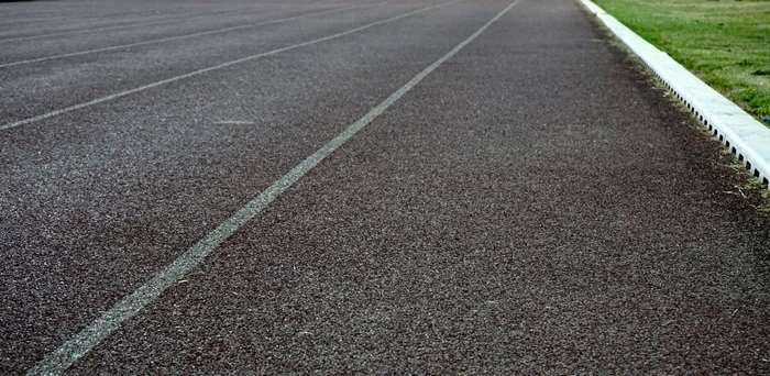 Running track with white lane lines and grass