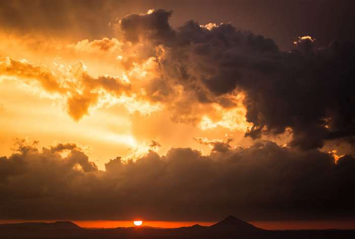 Golden Sunset with Dramatic Clouds Over Mountains