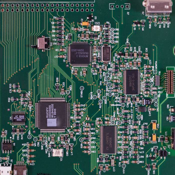 Close-up of a green printed circuit board with microchips and components