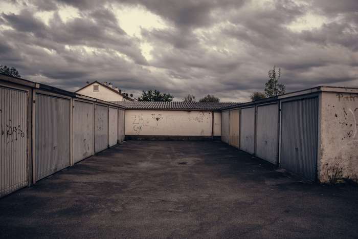 Gritty garage lot with graffiti under cloudy sky