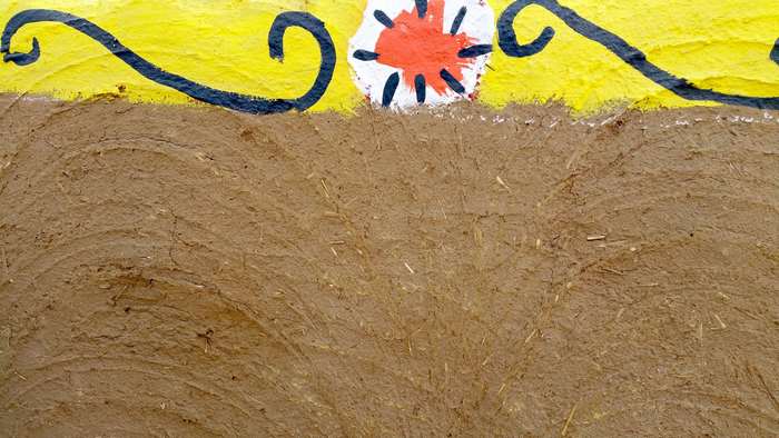 Yellow wall with tribal decoration and mud texture