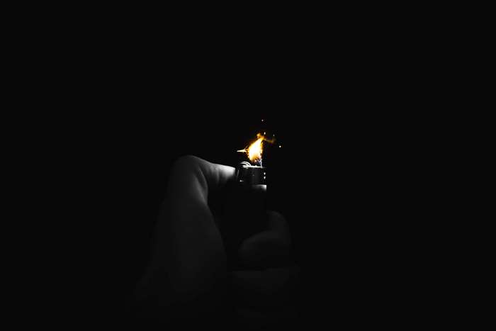 Hand holding a lighter with flame 4K