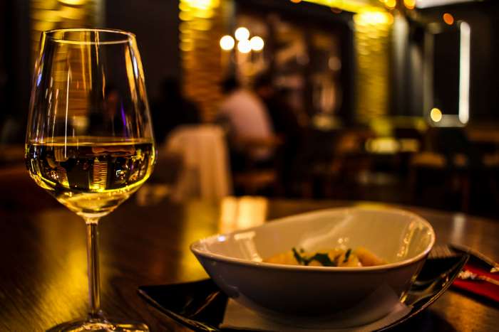 Glass of white wine and food in a restaurant