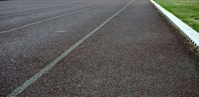 Running track with white lane lines and grass