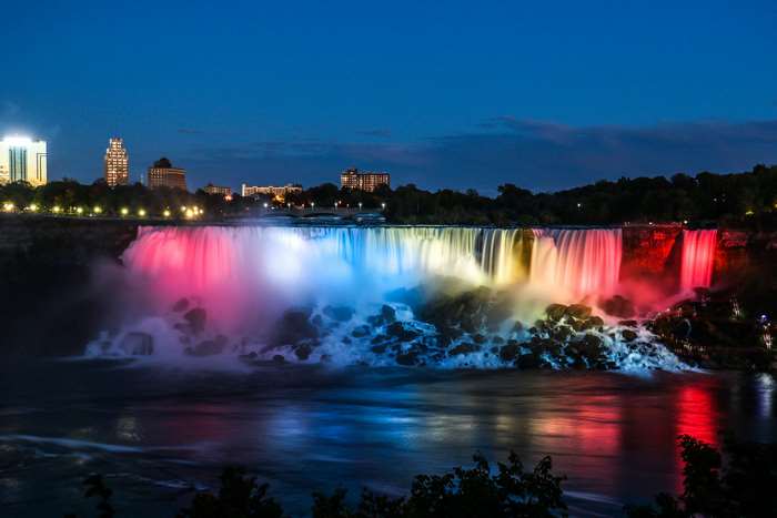 Niagara Falls illuminated at night with city skyline