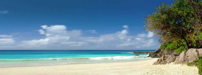 Beach panorama with turquoise ocean and rocky shore