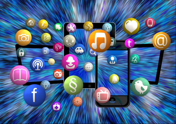 Social media and app icons floating around tablets and smartphones