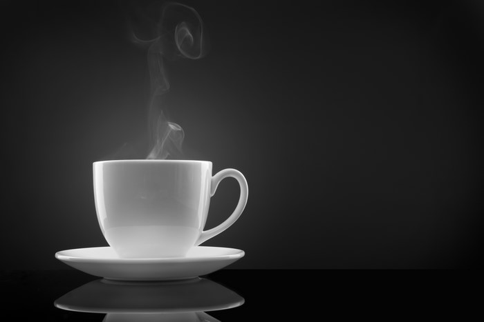 Steaming Hot Coffee in White Cup on Black