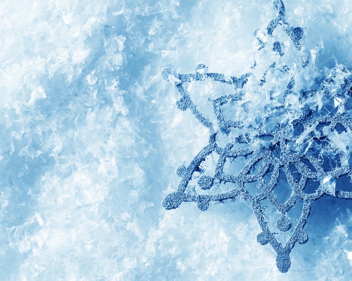Close-up of a blue glittery snowflake on ice