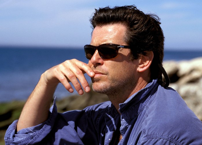 Pierce Brosnan wearing sunglasses by the sea