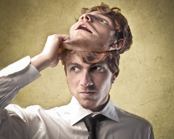 Man pulling off a mask of his own face