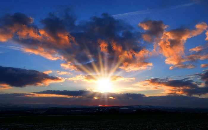 Radiant Sunset with Dramatic Clouds and Horizon