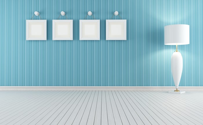 Four white frames on a blue striped wall with a white lamp