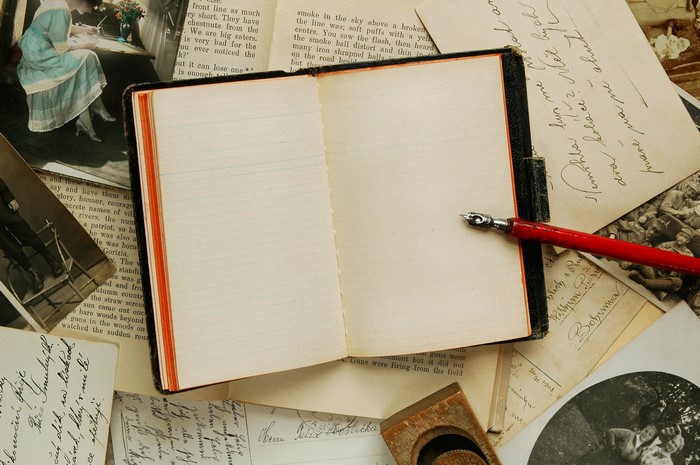 Open notebook with pen and old letters