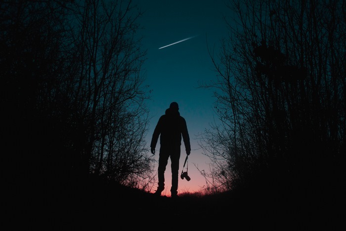 Silhouette of a photographer with a camera under a shooting star