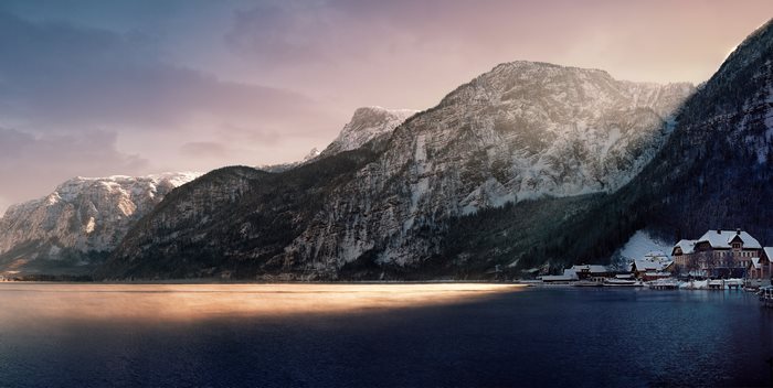 Snowy mountains over a lake with a village