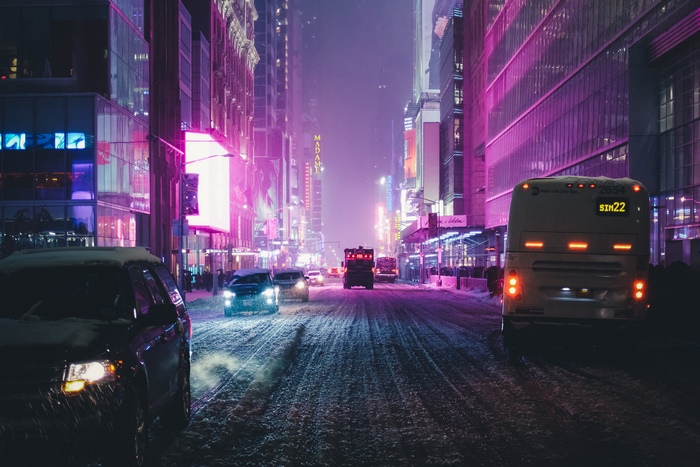 City street at night with neon lights and snow