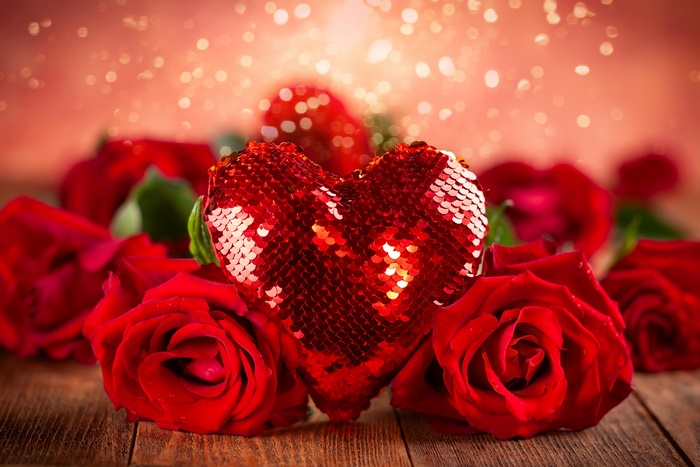 Red heart with red roses on wooden table