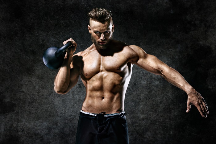 Muscular Man Lifting Kettlebell with Intense Focus