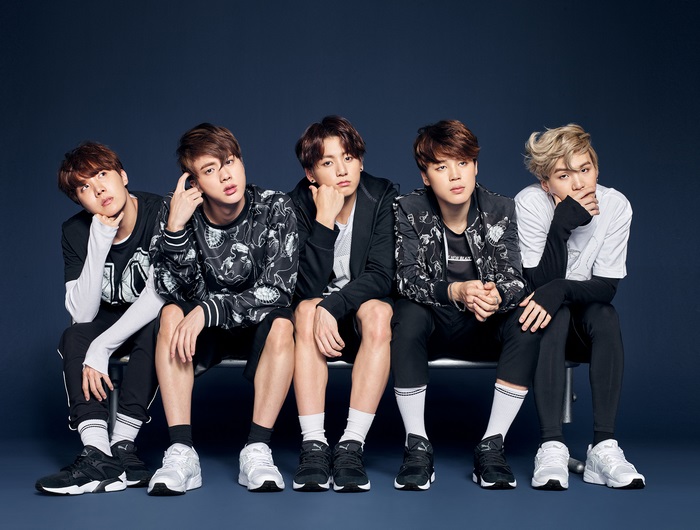 BTS members sitting on a bench