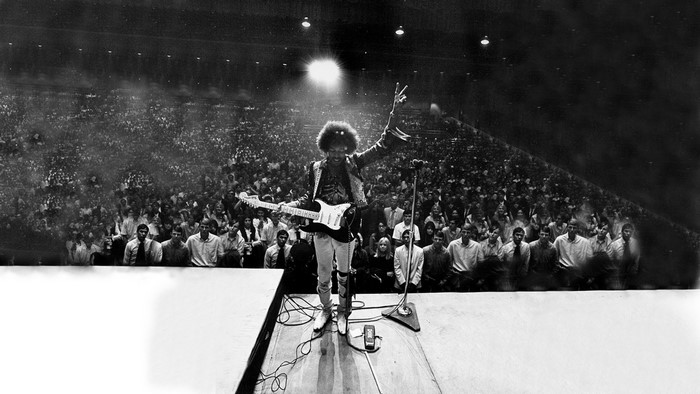 Jimi Hendrix performing on stage with a guitar