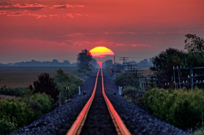 Sunset Over Railroad Tracks in Rural Landscape