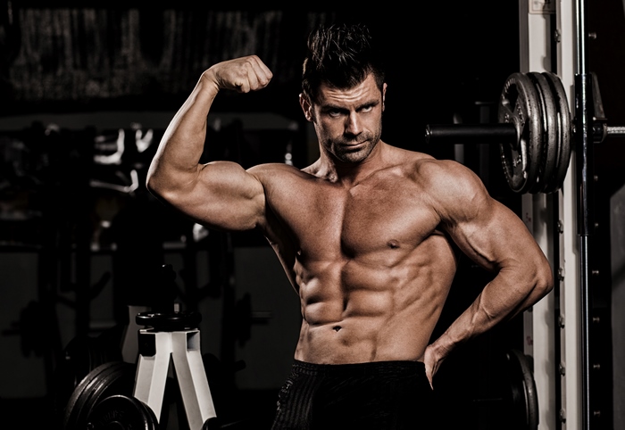 Bodybuilder flexing muscles in gym