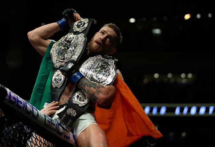 Conor McGregor holding two UFC championship belts