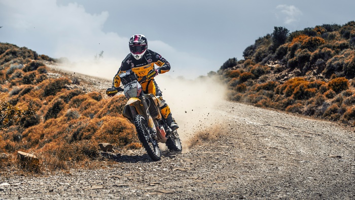 Motorcyclist racing on a dusty dirt road