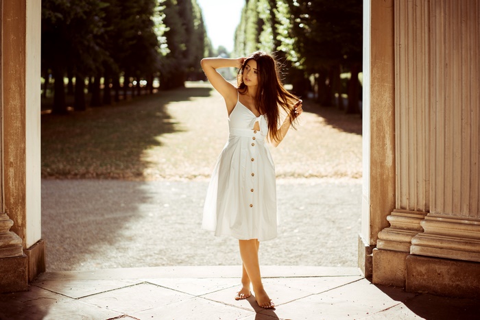 Woman in white dress standing in a park