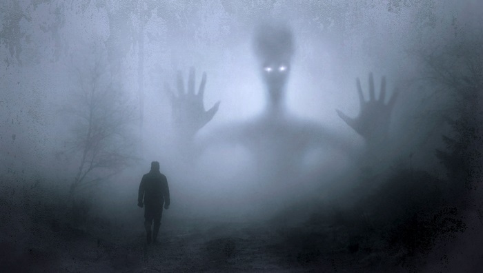 Man walks in fog towards a giant shadowy creature