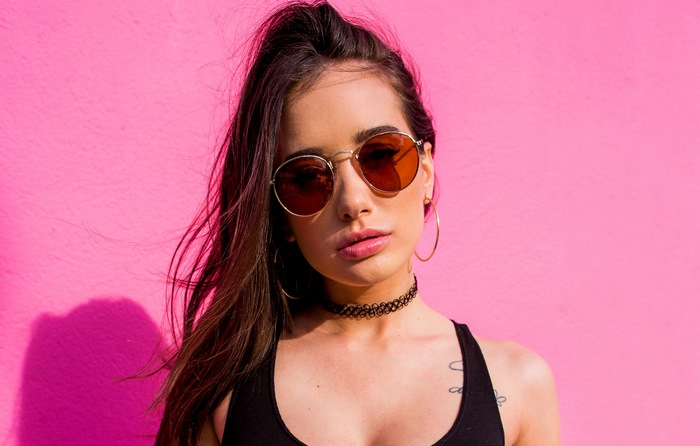 Gia Paige Wearing Sunglasses Against Pink Wall