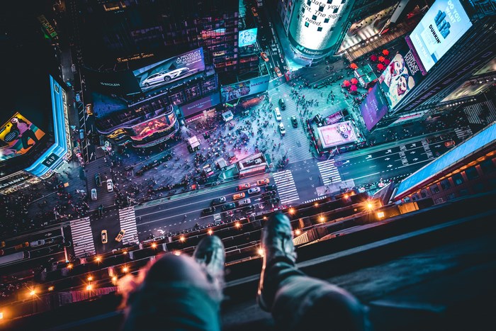 Person on rooftop overlooking Times Square at night