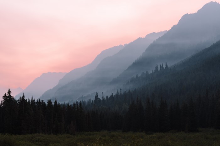 Misty mountain range with pink sky at sunrise