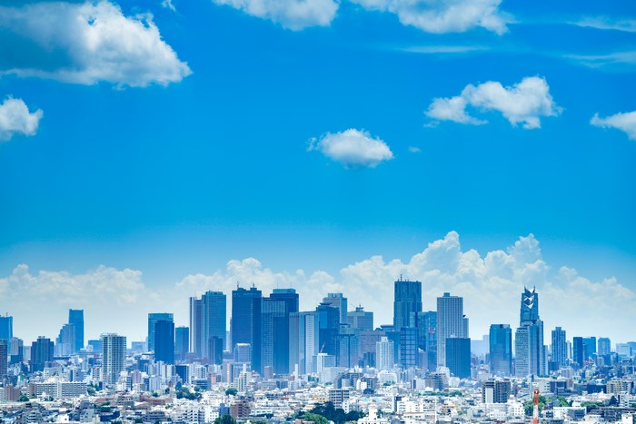 Tokyo cityscape with skyscrapers under a blue sky with clouds