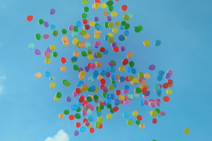Colorful balloons floating in a blue sky