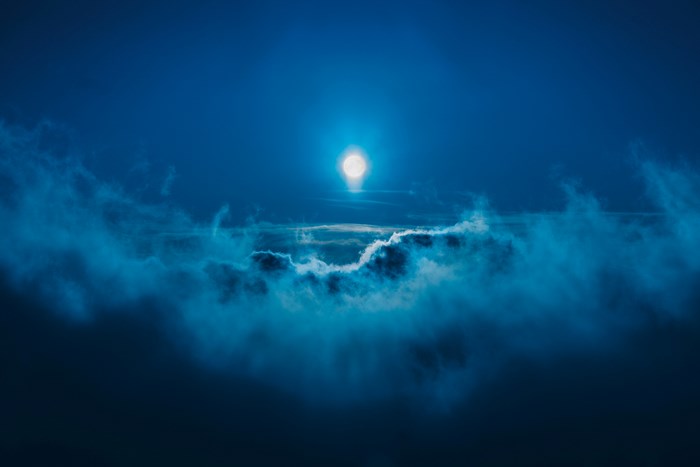 Moonlight shining through clouds at night