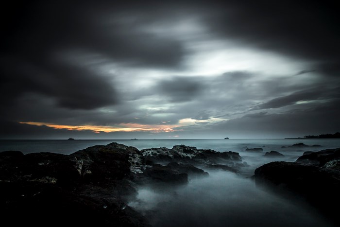 Moody long exposure of rocky coast at sunset