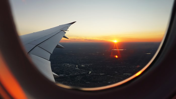 Airplane wing and sunset view from window