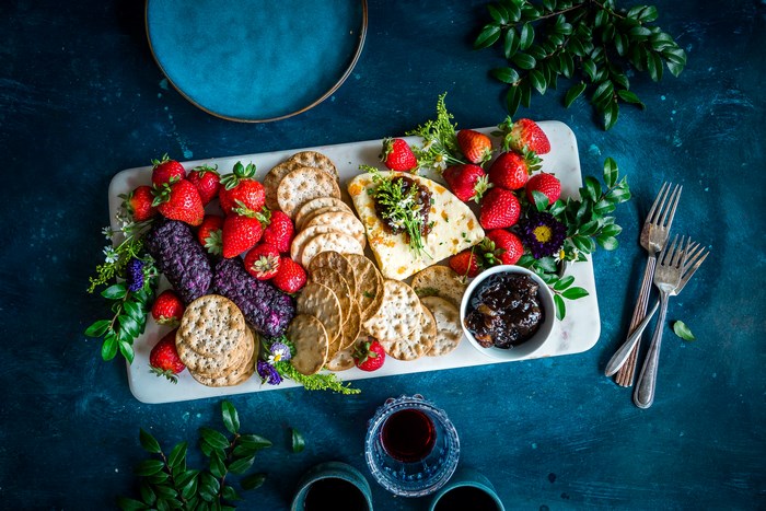 Cheese and fruit platter with crackers and jam