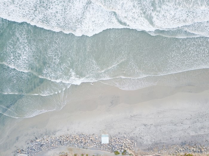 Aerial View of Ocean Waves Meeting Sandy Shore