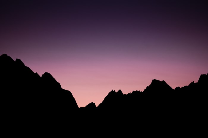 Silhouette of mountain range against purple and pink sky