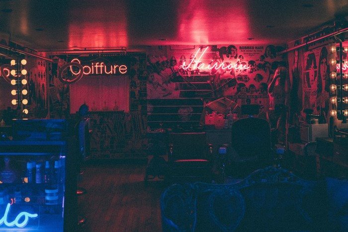 Hair salon with neon signs 'Coiffure' and 'Hairroom'